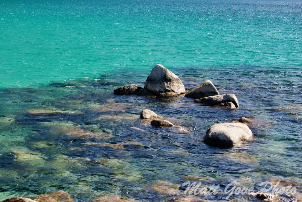 Lake Tahoe water and rocks watermarked with Python Pillow