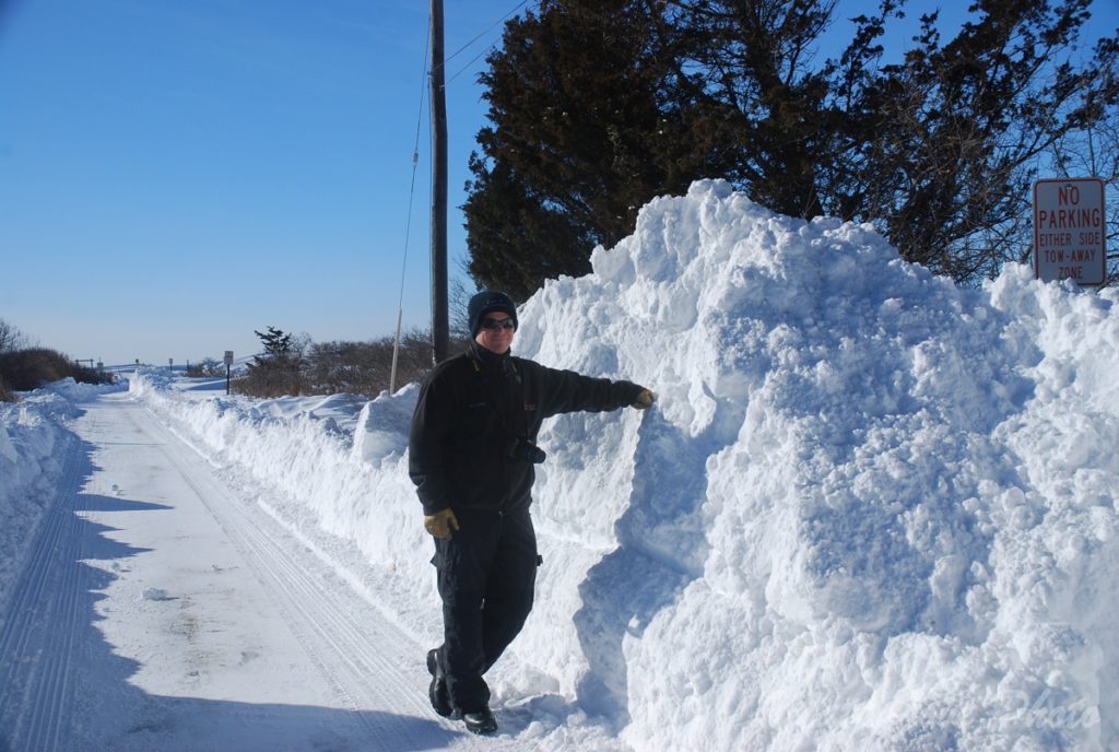 I stand next to an 8-foot high pile of snow after the 2015 Polar Vortex slammed New England.