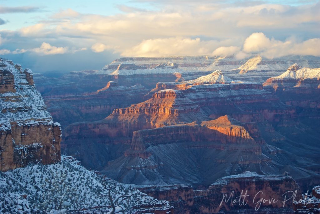 The soft evening sun shines on a snow-covered Grand Canyon