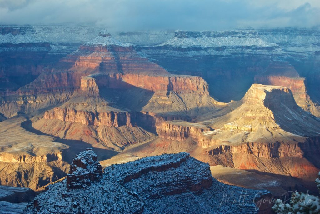 The setting sun illuminates spires inside the Grand Canyon after a winter storm