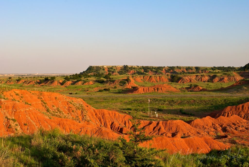 The setting sun casts a warm glow on Gloss Mountain State Park in Oklahoma