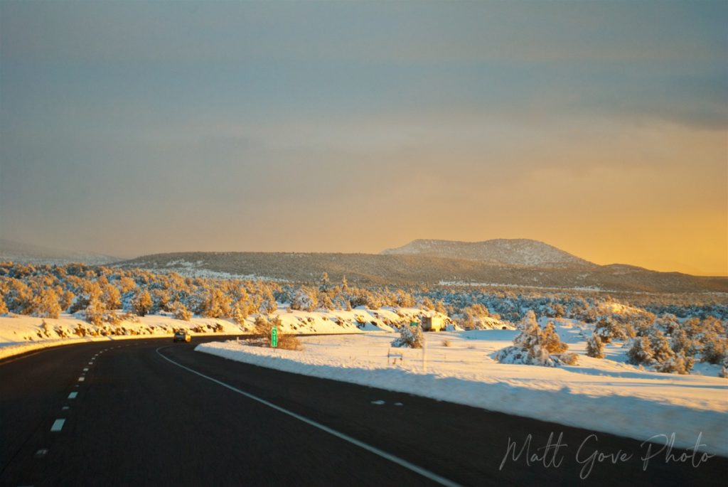 Low evening light illuminates a fresh snowfall along Interstate 17 in Arizona.