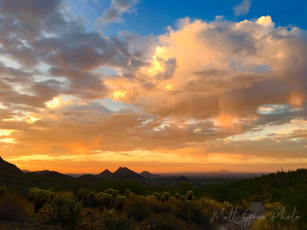 The rising sun illuminates virga over the McDowell Mountains in Scottsdale, Arizona